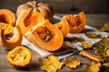 Sliced pumpkin with seeds on a wooden background. Close-up