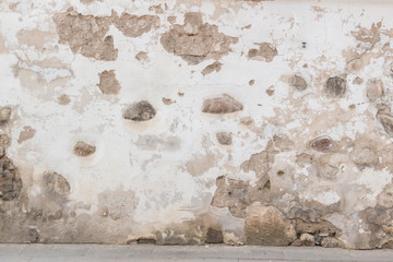 Grunge wall background. Old brick and stone wall with bright abandoned plaster