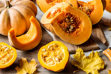 Sliced pumpkin with seeds on a wooden background. Close-up