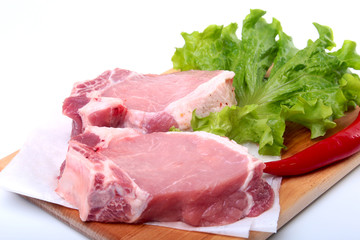 Raw pork chops with herbs and spices on cutting board. Ready for cooking.