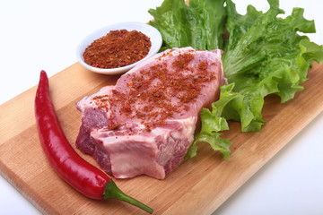 Raw pork chops with herbs and spices on cutting board. Ready for cooking.
