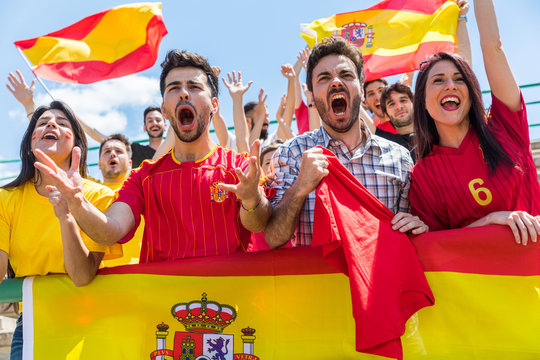 Spanish supporters cheering at stadium with flags