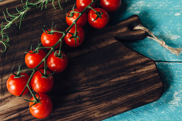 Freshly Picked Red Tomatoes on a Dark Wood Cutting Board