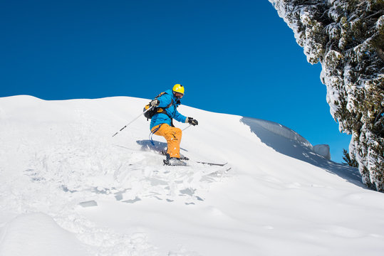 Male freerider skier riding downhill the slope in the mountains copyspace powder snow movement motion active lifestyle seasonal concept