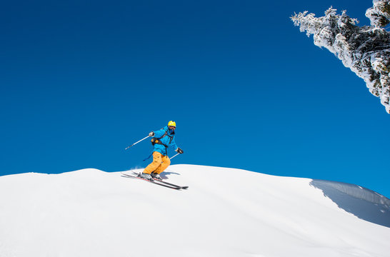 Freeride skier riding down the slope in the mountains copyspace powder snow movement motion active lifestyle seasonal concept