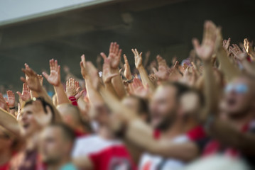 Football fans clapping on the podium of the stadium