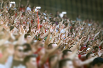 Football fans clapping on the podium of the stadium - obrazy, fototapety, plakaty