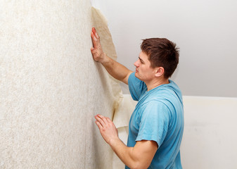 young worker smoothing wallpaper