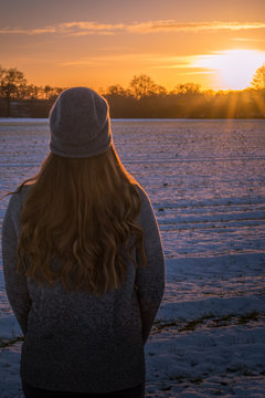 Frau vor Sonnenuntergang im Schnee