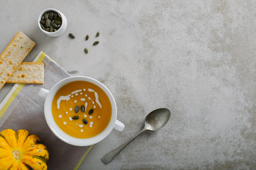 Seasonal pumpkin soup on light minimal background. Top view with copy space.