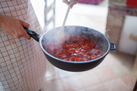 Man Cooking Tomato Sauce in the Pan for Spaghetti Pasta