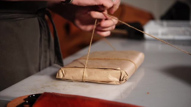 Craftsman finishing packing his product. He is going to sell it to the buyer