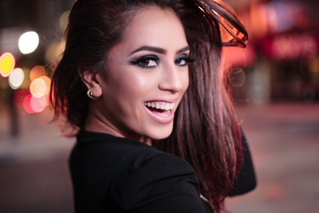 Young smiling attractive latina hispanic woman in downtown Miami night cityscape