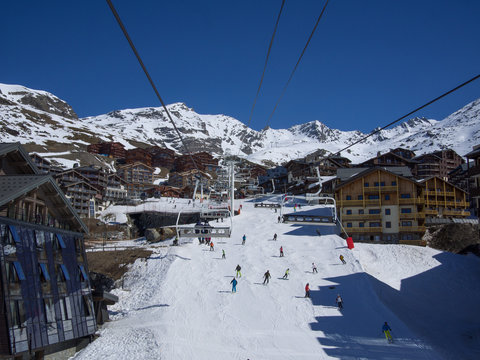Val Thorens, France _ March  18, 2017: Ski slope and chairlift in Val Thorens, people skiing in the middle of the village