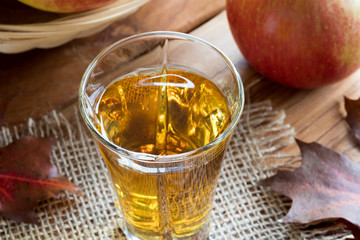 A glass of apple cider vinegar on a wooden table