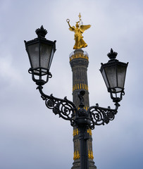 Fototapeta na wymiar Victory Column Siegessäule in Berlin behind street lamps