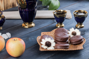 coffee on the table with background with cakes and apples