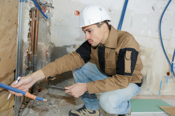 young plasterer worker at a indoors wall insulation works