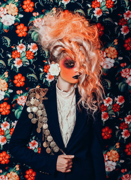 Fashion portrait of woman with orange hair and face paint