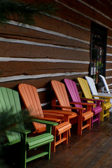 multicolored Adirondack chairs outside log cabin