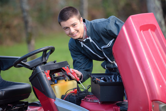 young man fixing a tractor