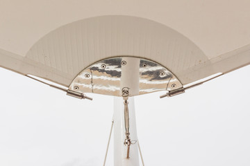 Construction details : Stainless steel support to round steel post of roof canvas with white sky...