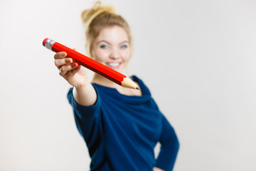 Happy woman holding giving big pencil