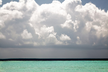 Beautiful tropical sea under the blue sky with big fluffy clouds.