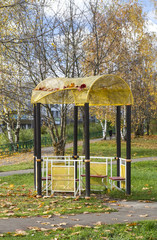 Metal gazebo sprinkled with autumn leaves