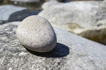Fototapeta na wymiar A small stone lies on a large background