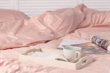 Fototapeta na wymiar Wooden tray with tasty breakfast on bed