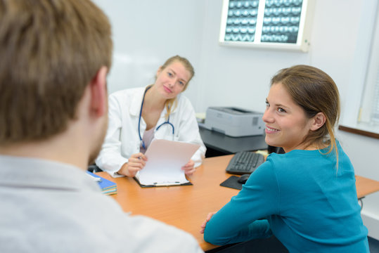 pretty female doctor while talking with young couple