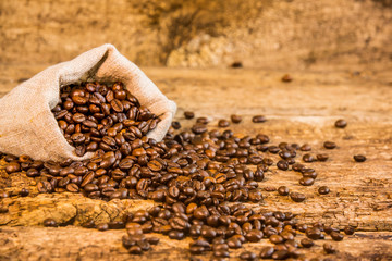 Coffee beans and bag on old wood background. Fresh coffee beans and bag on old wood.