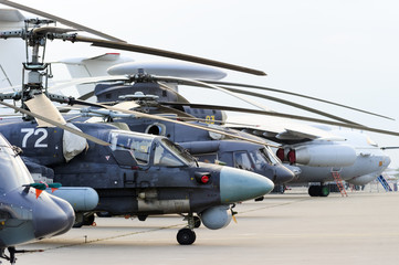 Fototapeta na wymiar Helicopters and planes in row, military copters and reconnaissance aircrafts, air force, modern army aviation and aerospace industry, dramatic clouds on background