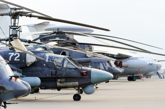 Helicopters and planes in row, military copters and reconnaissance aircrafts, air force, modern army aviation and aerospace industry, dramatic clouds on background