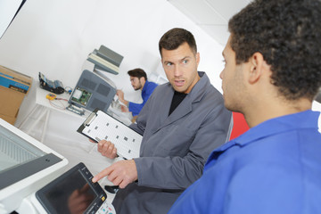 young photocopier repairer with experienced instructor