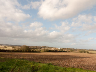 beautiful stretch of farm field landscape outside summer turning to autumn clear brown ploughed