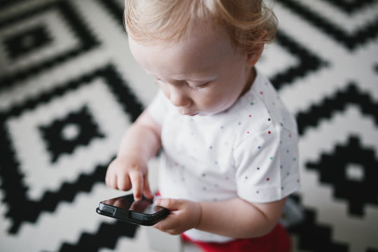 Precocious little child playing with a smart phone