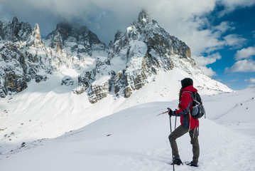 Young woman explorer looking at the mountain range in winter scenery