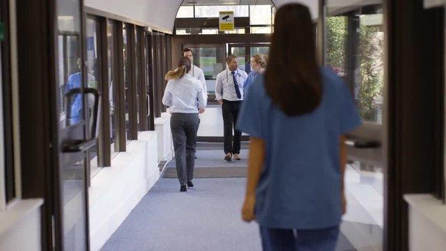  Medical team having a discussion as they walk through hospital hallway
