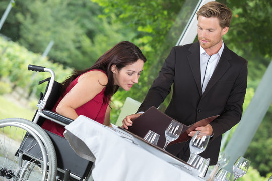 woman on a wheelchair having lunch at restaurant