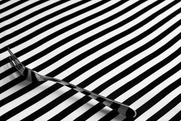 Fork on black and white striped geomtric background