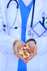 Doctor holding heap of drugs in a hand. Woman doctor
