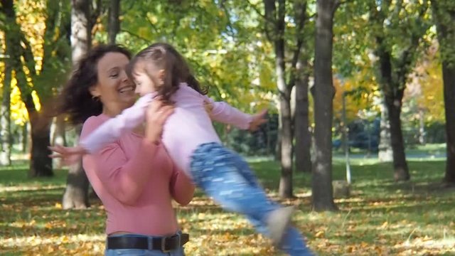 Happy family in autumn park. Mother circling a child in an autumn park.