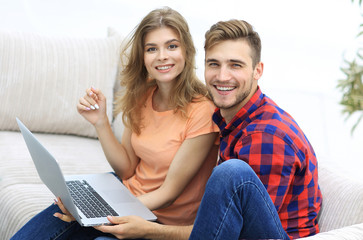 pair students with a laptop sitting on sofa