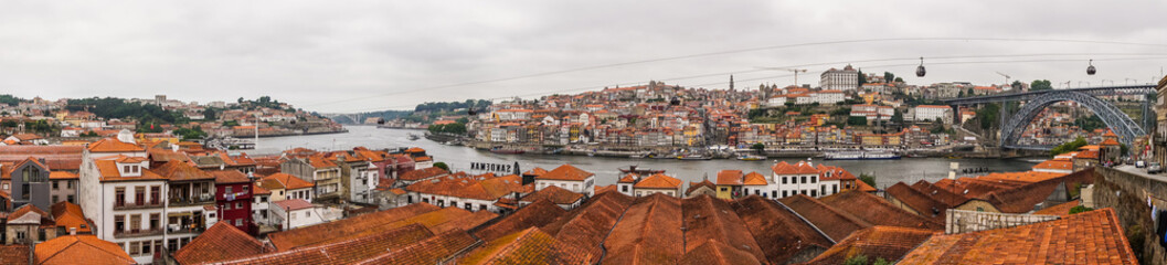 Fototapeta na wymiar View on Vila Nova de Gaia on Douro river in Porto, Portugal. British wine and port cellars - popular touristic attraction and destination for wine and port tasting with tours and excursions.