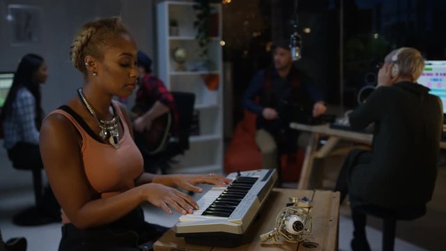  Band recording a track in home studio with technician at the mixing desk