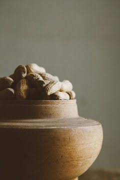 Raw peanuts in a wooden container.
