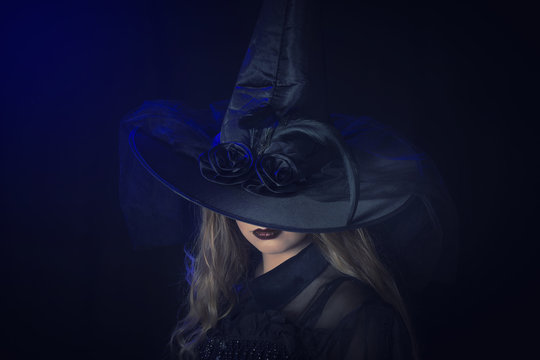 Beautiful woman in hat and leather gloves. Retro fashion model girl.black hat with large fields.Halloween witch