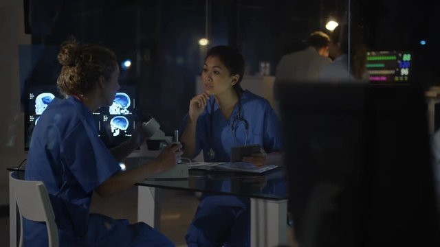  Hospital team on night shift using computers, focus on male doctor